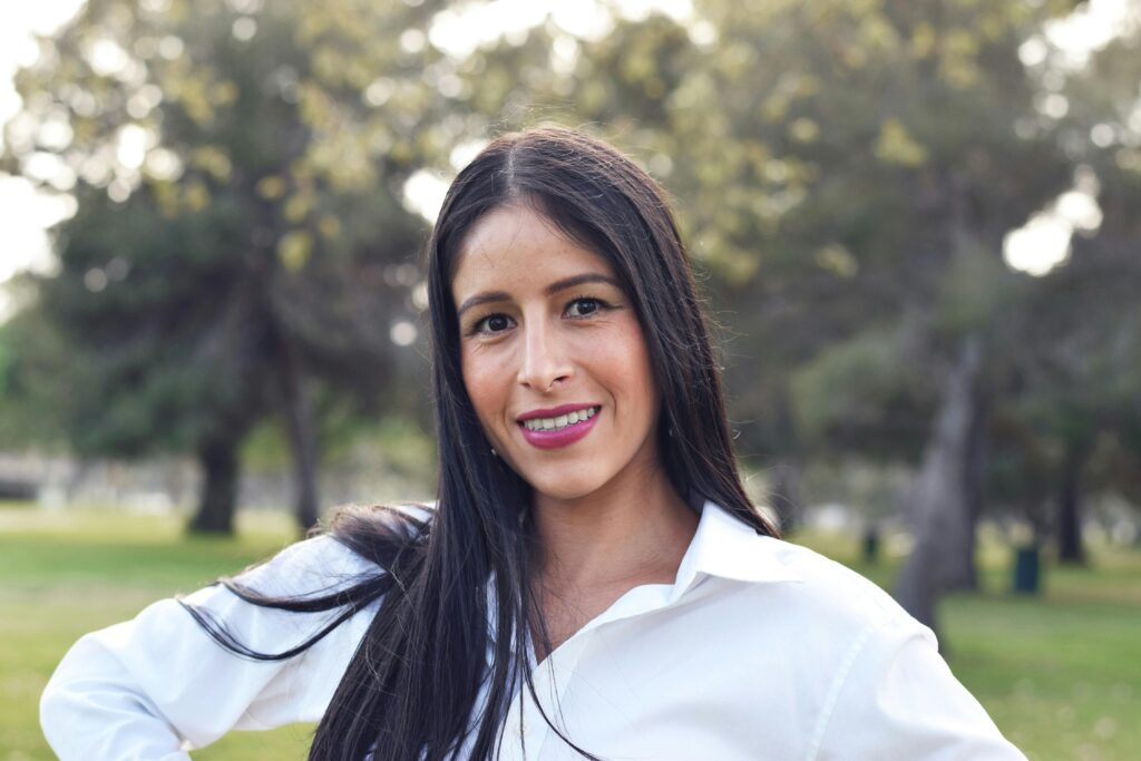 pexels-photo-29500278-29500278 Portrait of a young woman smiling outdoors in Long Beach park.