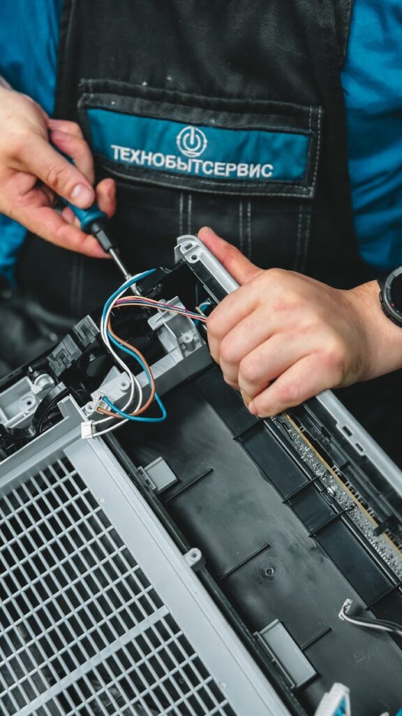 pexels-photo-32208779 Close-up of technician repairing a device, showcasing wiring and tools, ideal for tech and repair themes.