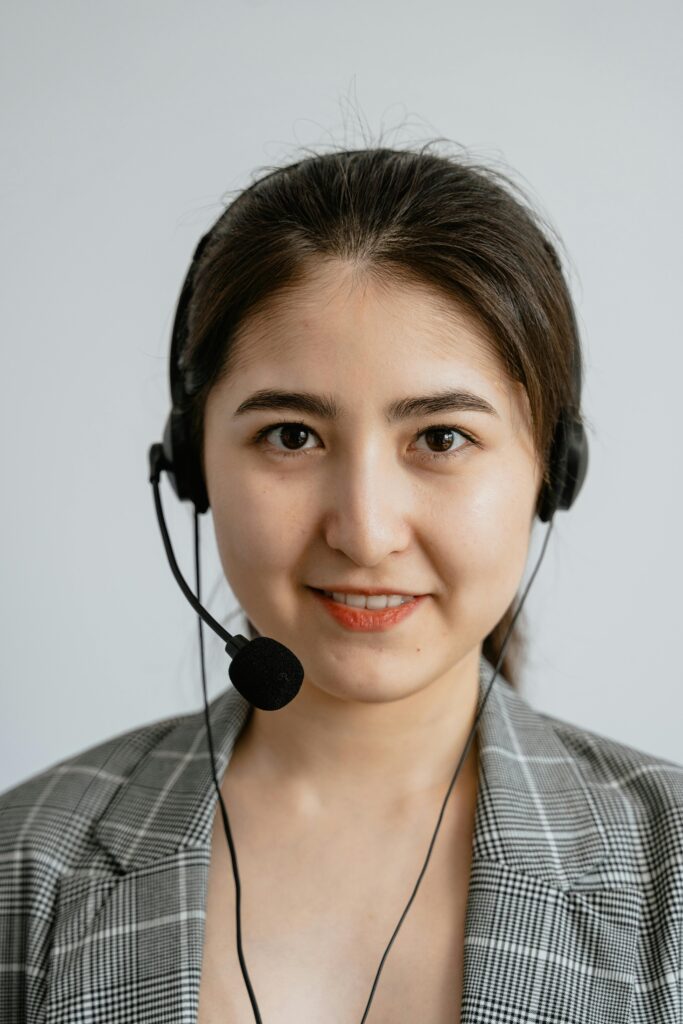 Smiling female call center agent wearing a headset, providing customer support.